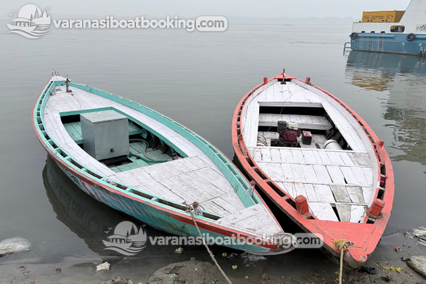 Two traditional motor boats moored beside the riverbank